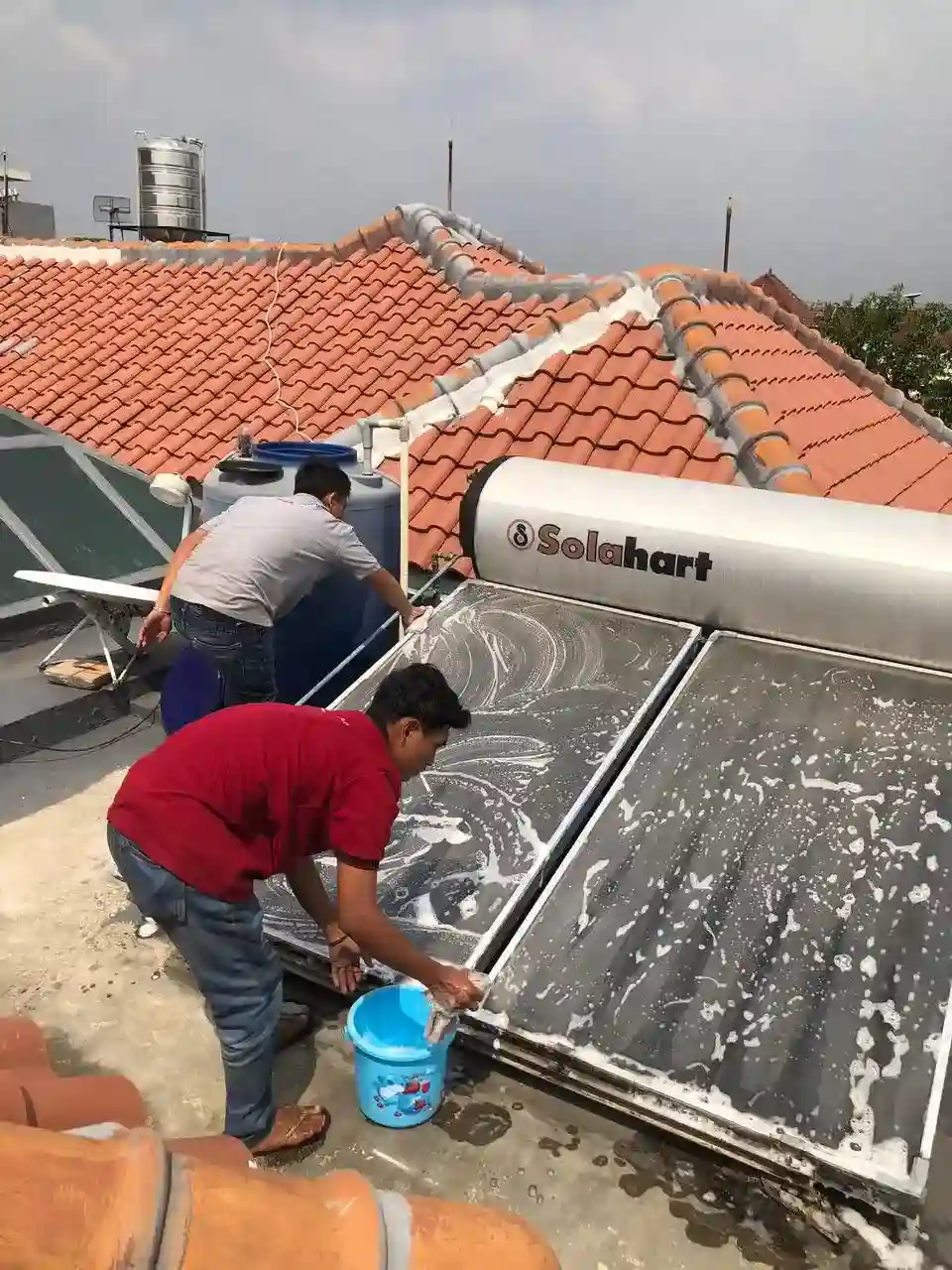 Proses pembersihan dan perawatan panel kolektor Solahart — layanan maintenance berkala oleh teknisi profesional Jakarta